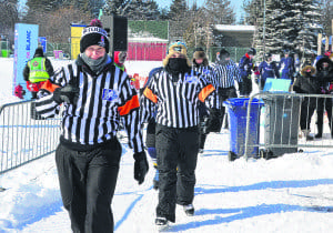 Bundled up against the fierce cold last weekend, referees and linesmen prepare for the match between the City of Laval and the SWLSB.